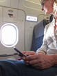 Close up of woman text messaging on cell phone in airplane