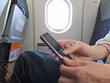 Close up of woman text messaging on cell phone in airplane