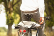 Close-up of coat and briefcase on back of young businessman's bicycle
