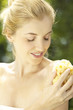 Portrait of young woman bathing with sponge outdoors