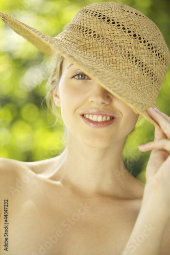 Photo: Portrait of young woman in straw hat outdoors Portrait of young woman in straw hat outdoors