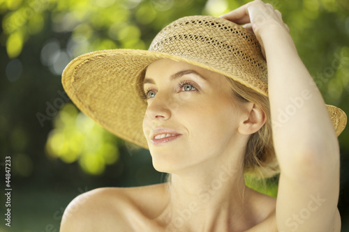 Photo: Portrait of young woman in straw hat outdoors Portrait of young woman in straw hat outdoors