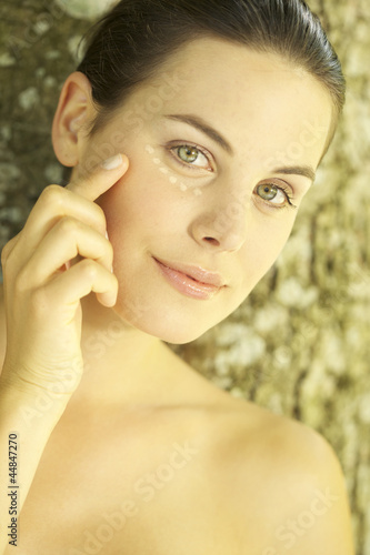 Photo: Portrait of young woman with foundation make-up dots under her eyes Portrait of young woman with foundation make-up dots under her eyes