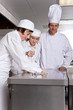Foto: Chef watching trainees cleaning work surface in commercial kitchen Chef watching trainees cleaning work surface in commercial kitchen