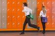 Boy rushing past student unlocking her school locker