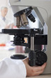 Technician adjusting microscope in laboratory