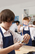 Photo: Student looking at plumbing faucet in vocational classroom Student looking at plumbing faucet in vocational classroom