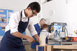 Student sawing wood in vise in vocational classroom