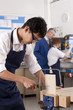 Student sawing wood in vise in vocational classroom