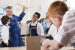 Teacher explaining wooden model airplane to students in vocational classroom