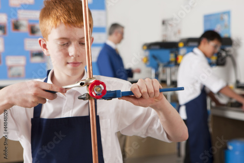 Photo: Student using wrench to tighten valve on cooper plumbing pipe Student using wrench to tighten valve on cooper plumbing pipe
