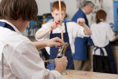 Photo: Student looking at plumbing faucet in vocational classroom Student looking at plumbing faucet in vocational classroom