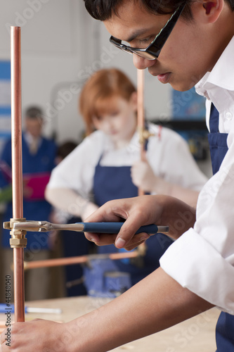 Photo: Student using wrench to tighten valve on cooper plumbing pipe Student using wrench to tighten valve on cooper plumbing pipe