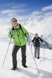Couple hiking up ski slope on mountain