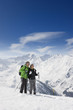 Couple hiking up ski slope on mountain