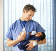 Doctor with baby bottle holding newborn baby boy in hospital