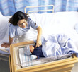 Mother looking at down at newborn baby boy in hospital crib