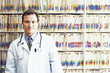 Portrait of smiling doctor in front of medical records on shelves