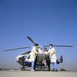 Photo: Doctors and paramedics rushing patient on gurney from emergency airlift helicopter Doctors and paramedics rushing patient on gurney from emergency airlift helicopter