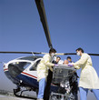 Photo: Doctors and paramedics rushing patient on gurney from emergency airlift helicopter Doctors and paramedics rushing patient on gurney from emergency airlift helicopter