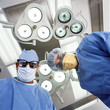 Photo: Portrait of surgeons under lamps in operating room Portrait of surgeons under lamps in operating room