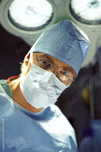 Photo: Close up portrait of surgeon in surgical mask and cap Close up portrait of surgeon in surgical mask and cap