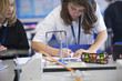 Girls taking notes near Bunsen burner in science class
