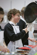 Boy holding frying pan in home economics class