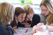 Science teacher helping students in laboratory classroom