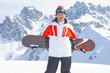 Portrait of smiling senior man with snowboard on snowy mountain