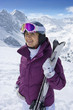 Foto: Smiling senior woman holding skis on snowy mountain Smiling senior woman holding skis on snowy mountain