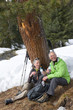 Foto: Portrait of happy couple with backpacks drinking water below tree in snowy woods Portrait of happy couple with backpacks drinking water below tree in snowy woods