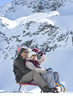 Smiling senior couple sledding on snowy mountain