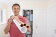 Photo: Portrait of man holding copper pipes in front of boiler in closet Portrait of man holding copper pipes in front of boiler in closet