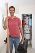 Photo: Portrait of smiling handyman with copper pipes and toolbox in front of boiler in closet Portrait of smiling handyman with copper pipes and toolbox in front of boiler in closet