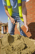 Bricklayer applying mortar to brick with trowel