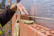 Close up of bricklayer setting brick wall