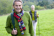 Portrait of smiling senior couple backpacking in field