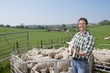 Portrait of shepherd holding lamb in pasture