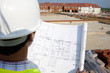 Close up of architect reviewing blueprints at construction site