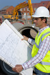 Photo: Architect reviewing blueprints at construction site Architect reviewing blueprints at construction site