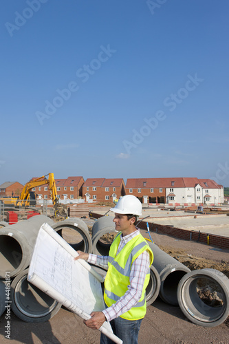 Photo: Architect reviewing blueprints at construction site Architect reviewing blueprints at construction site