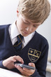 Photo: Close up of male student in school uniform using calculator Close up of male student in school uniform using calculator