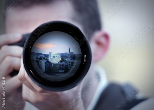 Photo: Photographer taking a picture in sunset close up Photographer taking a picture in sunset close up