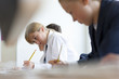 Photo: Students in school uniforms taking exam at desks in classroom Students in school uniforms taking exam at desks in classroom