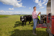 Portrait of farmer preparing feed for cattle on truck bed in sunny rural field