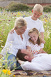 Family relaxing in sunny wildflower field