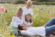 Family relaxing in sunny wildflower field