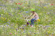 Girl riding bicycle in wildflower field