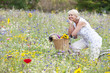 Smiling woman sitting on bicycle in field of wildflowers